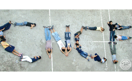 Children from Vietnam spell out the Charity Initials