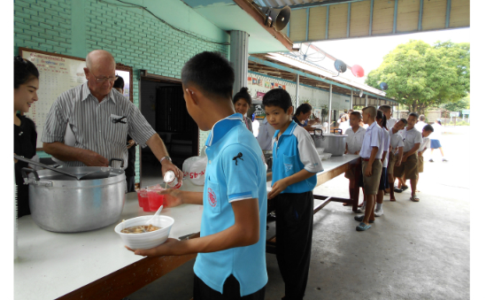 Feeding children at school in Thailand on his birthday