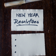 New Year Resolutions - Paper and pen on a wooden desk