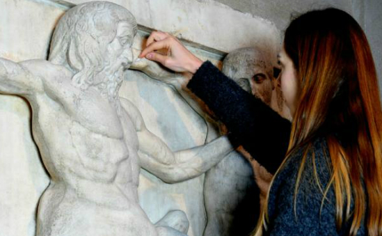 Conservator performing cleaning tests on a Parthenon metope